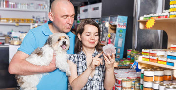 Which Natural Foods Are Best for Your Dog's Overall Health & Well-Being? Image of man and women buying dog food.